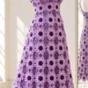Lilac crochet flower empire dress on mannequin showing eight-petal motifs with plum centers and flared skirt